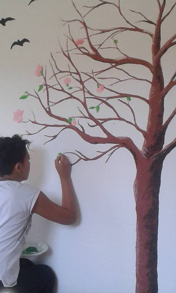 Ragazza che dipinge durante il laboratorio di murales